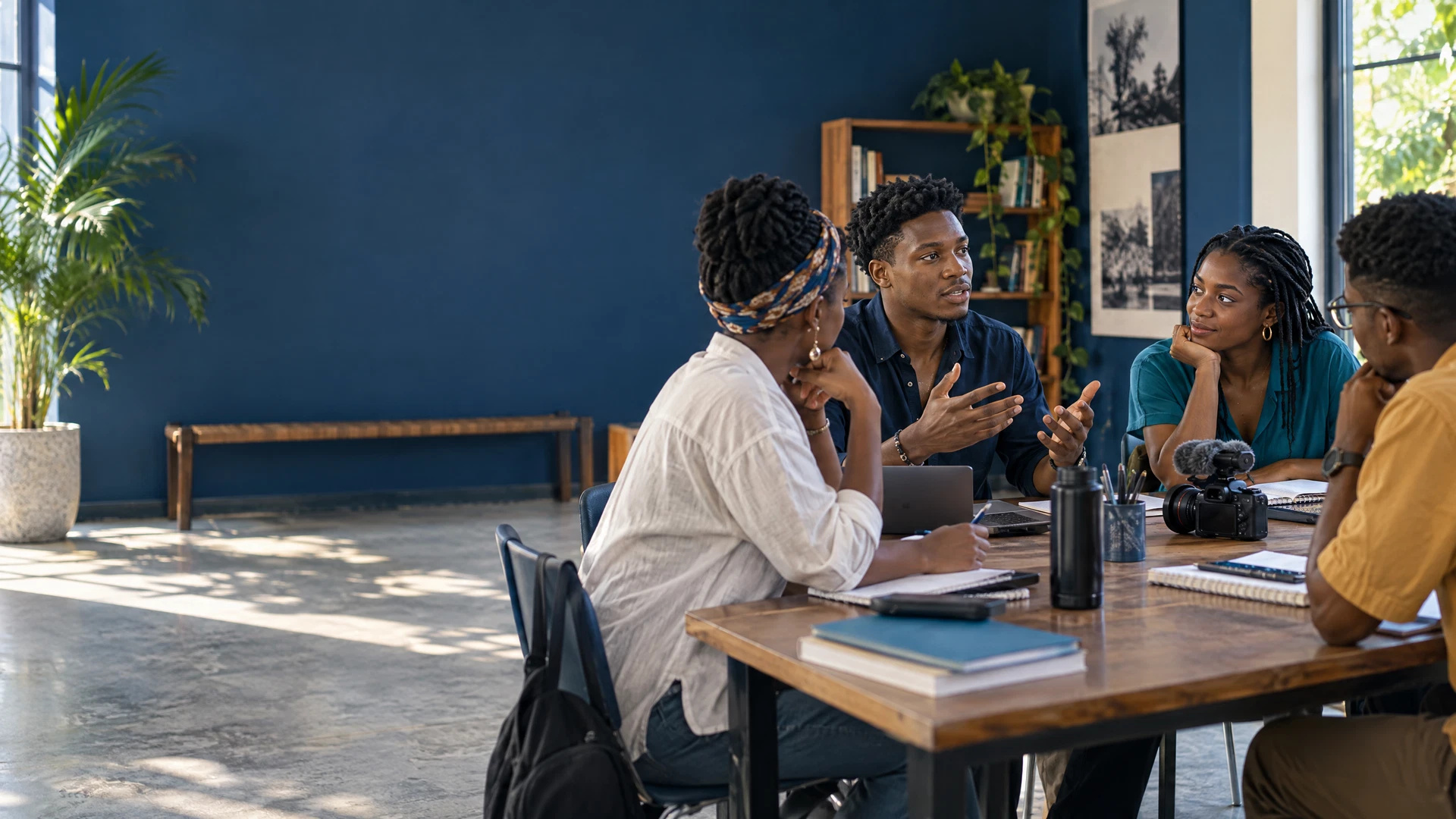 Jeunes adultes haïtiens échangeant et apprenant ensemble autour d’une table.
